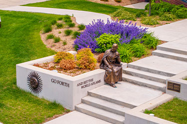 Photo of a statue sitting by flower beds. Link to Life Stage Gift Planner Over Age 70 Situations.